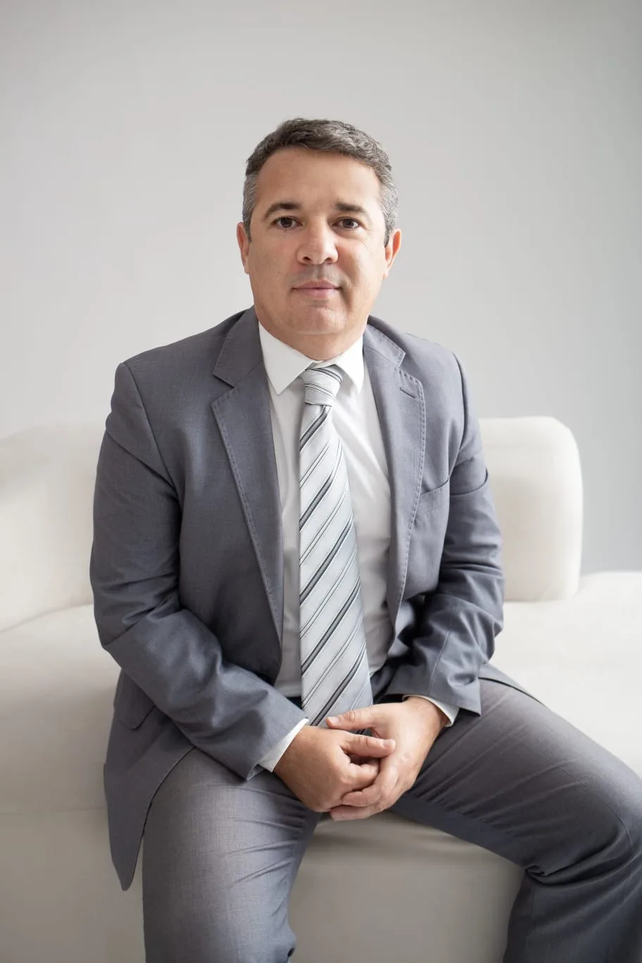 Retrato do advogado Vinicios Araujo de Souza, de terno cinza e gravata listrada